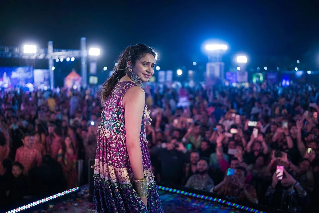 Kinjal Dave performing on stage with the Killol audience behind her